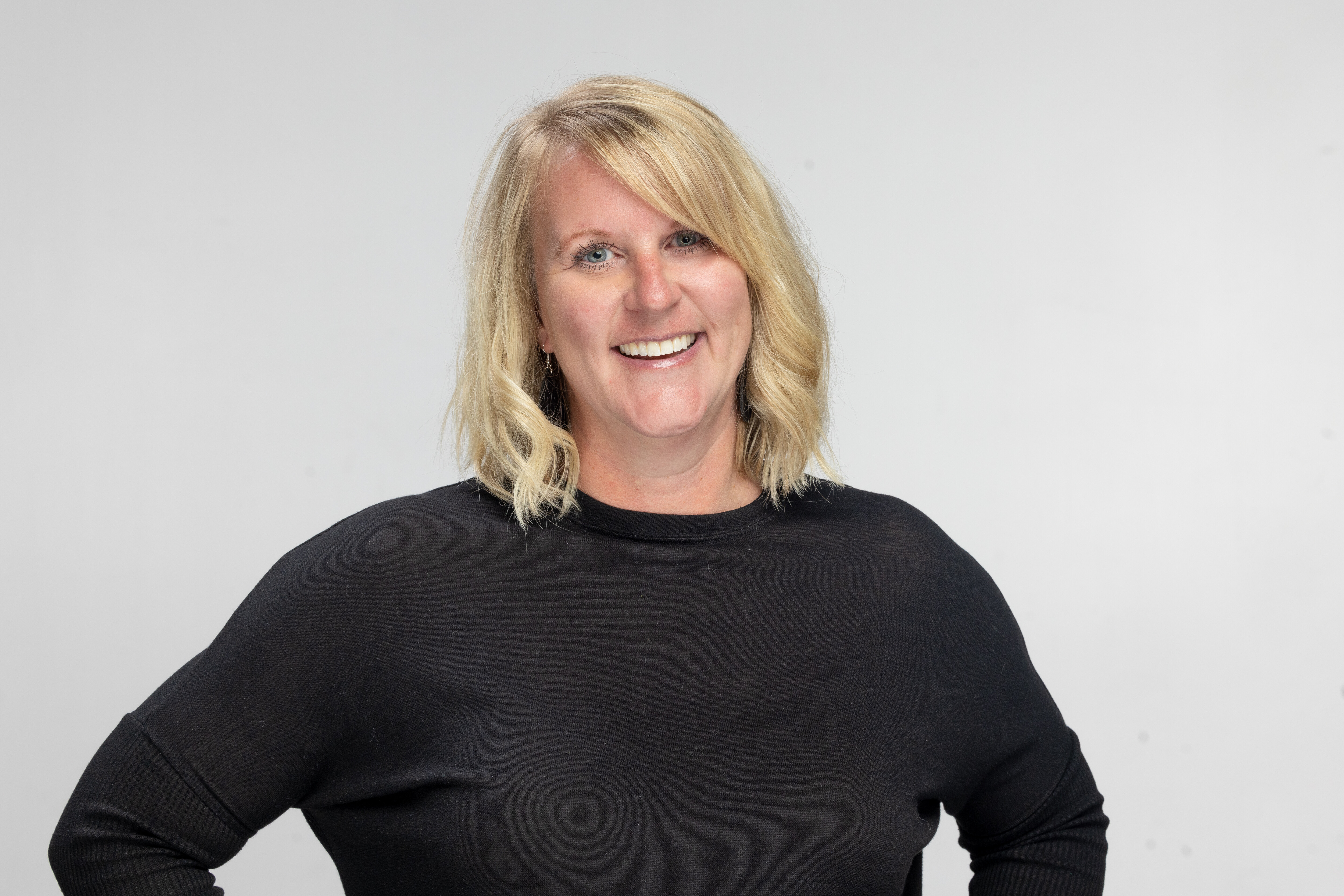 Woman stares at camera in black shirt, smiling