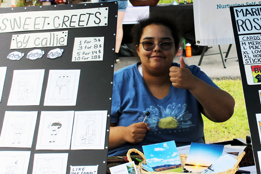 Person with greeting cards offering a thumbs up.