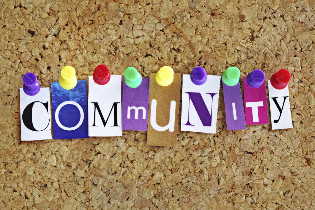 letters tacked on a cork board to spell community