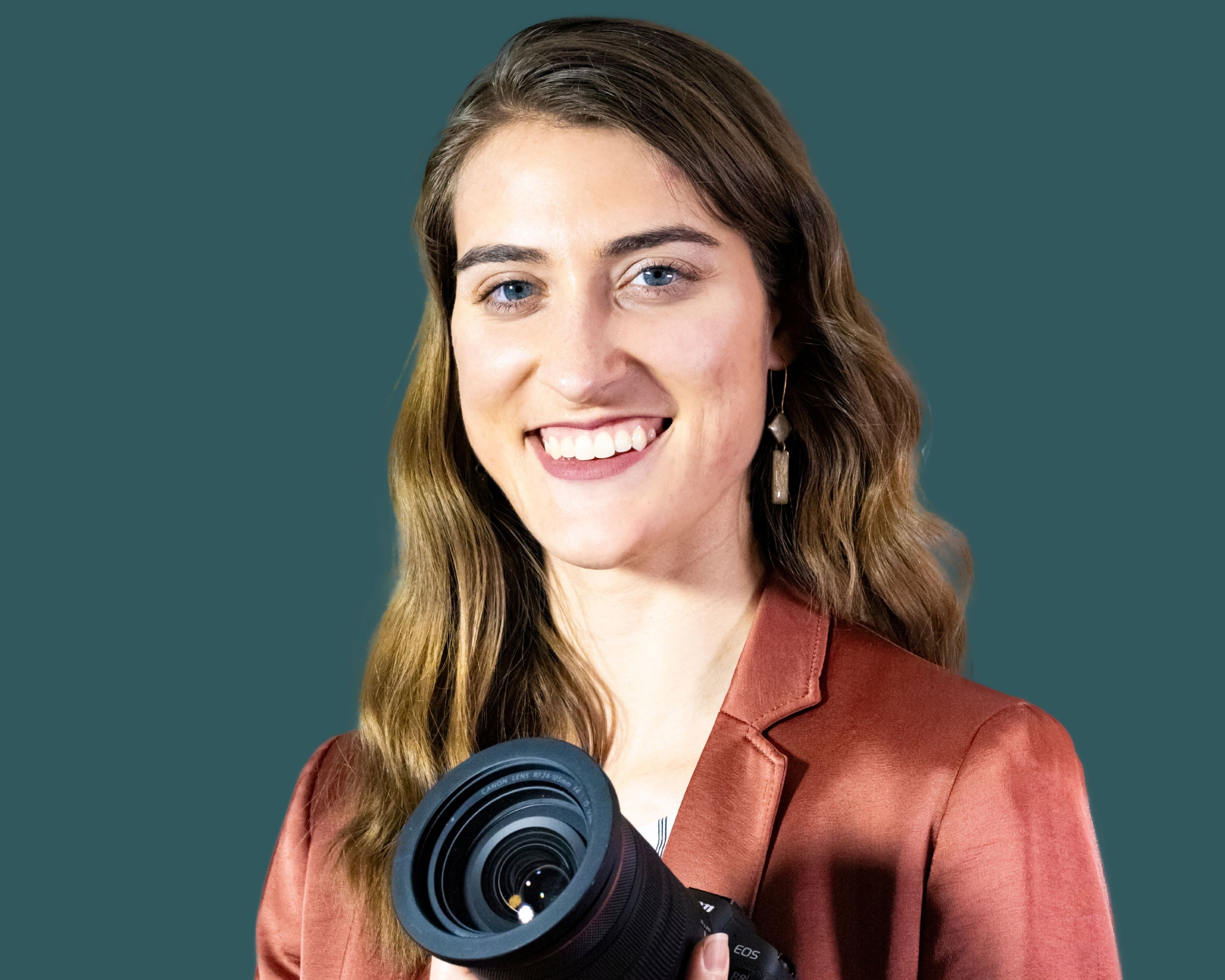 A woman smiling and holding a camera